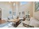 Bright and airy living room with soaring ceilings, large windows, and comfortable seating at 23320 Dinhurst Ct, Land O Lakes, FL 34639