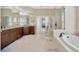 Large bathroom featuring double sinks, granite counters, soaking tub, and glass enclosed shower at 23320 Dinhurst Ct, Land O Lakes, FL 34639