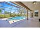 Screened-in pool area with spacious patio, fan, and view of well-manicured landscaping at 23320 Dinhurst Ct, Land O Lakes, FL 34639