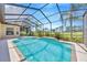 Screened-in pool with clear blue water surrounded by lush landscaping and views of the golf course at 23320 Dinhurst Ct, Land O Lakes, FL 34639