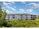 Exterior view of the condo building featuring screened balconies and mature landscaping at 2725 Terra Ceia Bay Blvd # 104, Palmetto, FL 34221