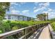 View of condo building through lush, mature landscaping and a wooden boardwalk at 2725 Terra Ceia Bay Blvd # 104, Palmetto, FL 34221