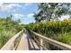 Wooden walkway surrounded by tropical landscaping under a bright blue sky at 2725 Terra Ceia Bay Blvd # 104, Palmetto, FL 34221