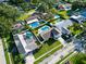 Aerial view of a home and neighborhood with green lawns, mature trees, and a residential street at 2897 Rosery Ne Rd, Largo, FL 33771