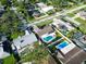 Aerial shot of a home with a pool and screened lanai in a neighborhood with lush greenery at 2897 Rosery Ne Rd, Largo, FL 33771