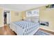 Comfortable bedroom featuring wood-look flooring, a bed with blue floral bedding, and an open closet at 2897 Rosery Ne Rd, Largo, FL 33771