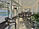 Screened-in lanai with in-ground pool views, a seating area, an outdoor bar, and a pass-through window to the kitchen at 2897 Rosery Ne Rd, Largo, FL 33771