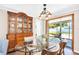 Bright dining room with glass table, vintage cabinet, and sliding doors to sunroom, perfect for entertaining at 2897 Rosery Ne Rd, Largo, FL 33771