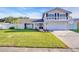 A charming two-story home displays a well-manicured front lawn, a balcony, and a two-car garage at 2897 Rosery Ne Rd, Largo, FL 33771
