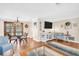 Open-concept living and dining area with hardwood floors, a mounted TV, and modern decor at 2897 Rosery Ne Rd, Largo, FL 33771
