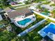 Aerial view of backyard featuring a sparkling pool, screened-in patio, and well-maintained lawn at 2897 Rosery Ne Rd, Largo, FL 33771