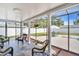 Relaxing sunroom with wicker seating and screened windows with a view of the backyard and patio at 2897 Rosery Ne Rd, Largo, FL 33771