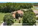 An aerial view showcases a lush landscaped home featuring mature trees and a well manicured lawn at 3042 Wentworth Way, Tarpon Springs, FL 34688