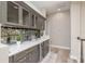 Chic wet bar featuring sleek cabinetry, marble countertops, mirrored backsplash, and beverage cooler at 3042 Wentworth Way, Tarpon Springs, FL 34688