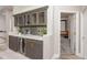Stylish wet bar with wine fridge, marble counters, and glass cabinets near the entrance of home theater at 3042 Wentworth Way, Tarpon Springs, FL 34688