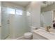 This renovated bathroom has a glass shower door and a white vanity with gold fixtures at 3042 Wentworth Way, Tarpon Springs, FL 34688