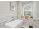 Elegant bathroom features a freestanding tub, marble accents, and bright window, creating a serene atmosphere at 3042 Wentworth Way, Tarpon Springs, FL 34688