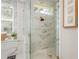 Luxurious bathroom shower with marble walls, glass door, and gold fixtures, offering a spa-like experience at 3042 Wentworth Way, Tarpon Springs, FL 34688