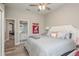 Cozy bedroom with a tufted headboard bed, ceiling fan, and view to ensuite bathroom at 3042 Wentworth Way, Tarpon Springs, FL 34688