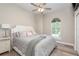 Bright bedroom features a plush bed, arched window, hardwood floors, and soft, neutral décor at 3042 Wentworth Way, Tarpon Springs, FL 34688