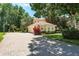 A home featuring a paved driveway, three-car garage and well-kept landscaping at 3042 Wentworth Way, Tarpon Springs, FL 34688