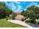 Aerial view of a well-maintained home, featuring a brick driveway and lush green landscaping at 3042 Wentworth Way, Tarpon Springs, FL 34688