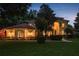 Stunning home at twilight with warm exterior lighting and manicured landscaping at 3042 Wentworth Way, Tarpon Springs, FL 34688