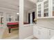 View of a game room with pool table alongside a bar featuring custom cabinetry and marble countertops at 3042 Wentworth Way, Tarpon Springs, FL 34688