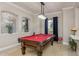 A beautifully decorated game room featuring a pool table, decorative windows, and elegant lighting fixtures at 3042 Wentworth Way, Tarpon Springs, FL 34688