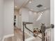 Upstairs hallway featuring wood floors, decorative railing, and stylish lighting, leading to living areas at 3042 Wentworth Way, Tarpon Springs, FL 34688