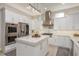 Modern kitchen featuring white cabinets, stainless steel appliances, marble countertops, and a kitchen island at 3042 Wentworth Way, Tarpon Springs, FL 34688