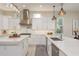 Bright kitchen featuring white cabinets, marble countertops, stainless steel appliances, and modern pendant lights at 3042 Wentworth Way, Tarpon Springs, FL 34688