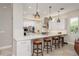 Open-concept kitchen featuring white cabinets, marble countertops, and stainless steel appliances at 3042 Wentworth Way, Tarpon Springs, FL 34688