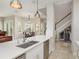 Kitchen with island, dining space, and staircase with wine storage at 3042 Wentworth Way, Tarpon Springs, FL 34688