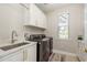 Laundry room featuring modern appliances, white cabinets, and a sink at 3042 Wentworth Way, Tarpon Springs, FL 34688