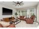 A comfortable living room with leather furniture, large windows, and a ceiling fan at 3042 Wentworth Way, Tarpon Springs, FL 34688