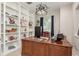 A stylish office with custom built-in shelves and a classic wood desk creates a professional workspace at 3042 Wentworth Way, Tarpon Springs, FL 34688