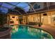 The covered lanai includes an outdoor kitchen, multiple sitting areas, and a beautiful pool at 3042 Wentworth Way, Tarpon Springs, FL 34688