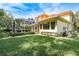 The home features a screened-in lanai, lush landscaping, and a well-manicured lawn at 3042 Wentworth Way, Tarpon Springs, FL 34688