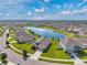 Aerial view of a neighborhood surrounding a picturesque lake, showcasing the homes and community layout at 30732 Summer Sun Loop, Wesley Chapel, FL 33545