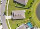Aerial view showing a well-maintained home with a pool, surrounded by a green lawn and a nearby lake at 30732 Summer Sun Loop, Wesley Chapel, FL 33545
