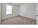 Empty bedroom featuring neutral carpet, baseboards, and a window for natural light at 30732 Summer Sun Loop, Wesley Chapel, FL 33545