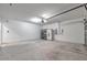 Spacious garage with storage cabinets, a clean concrete floor, and a garage door on the right at 30732 Summer Sun Loop, Wesley Chapel, FL 33545