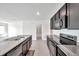 Well-lit kitchen with stainless steel appliances, a large island with a sink and granite countertops at 30732 Summer Sun Loop, Wesley Chapel, FL 33545