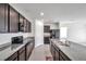 Well-equipped kitchen featuring granite countertops, dark cabinetry, and modern stainless steel appliances at 30732 Summer Sun Loop, Wesley Chapel, FL 33545