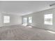 Sunlit living room boasts neutral tones and multiple windows, creating a warm and inviting atmosphere at 30732 Summer Sun Loop, Wesley Chapel, FL 33545