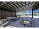 Covered outdoor lounge area with comfortable seating, dining space, and a view of the pool at 31172 Pendleton Landing Cir, Wesley Chapel, FL 33545