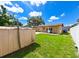 Private backyard with lush green lawn, convenient storage shed, and secure white fencing at 3303 W Idlewild Ave, Tampa, FL 33614