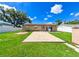 Spacious backyard featuring a concrete patio, lush green lawn, and secure fencing at 3303 W Idlewild Ave, Tampa, FL 33614