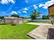 Lush backyard featuring a well-maintained lawn, a shed, a concrete patio, and a bright blue sky at 3303 W Idlewild Ave, Tampa, FL 33614